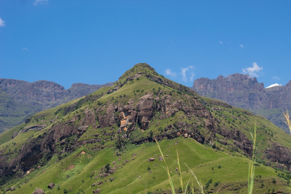 a large green mountain with a sky background