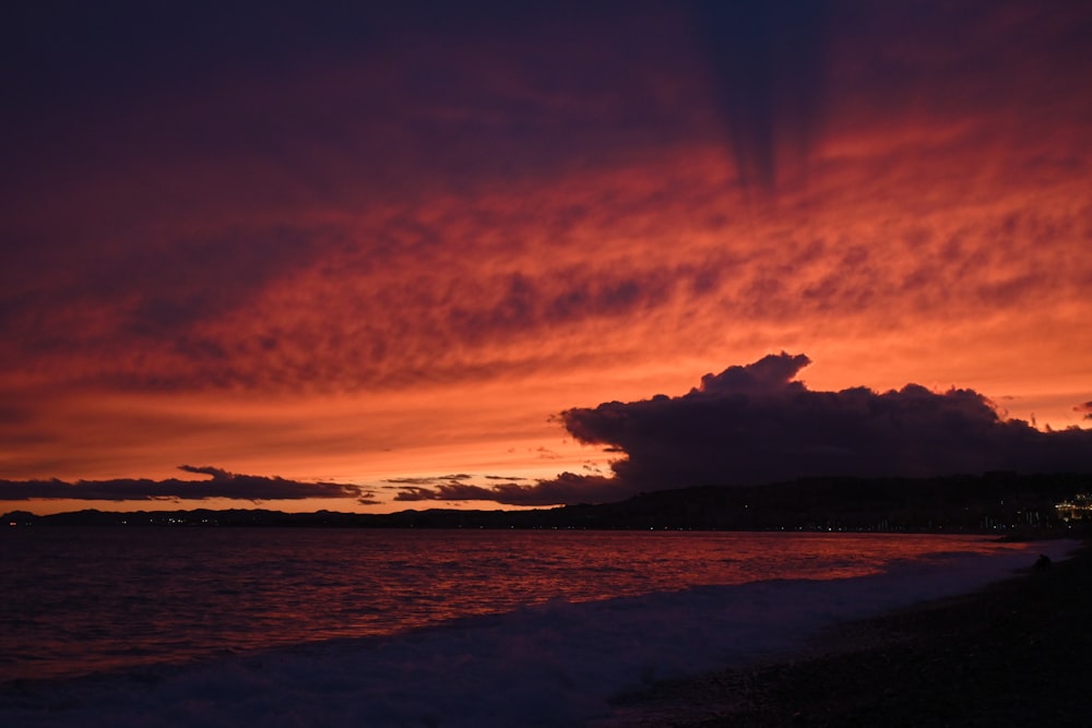 a red and purple sunset over a body of water