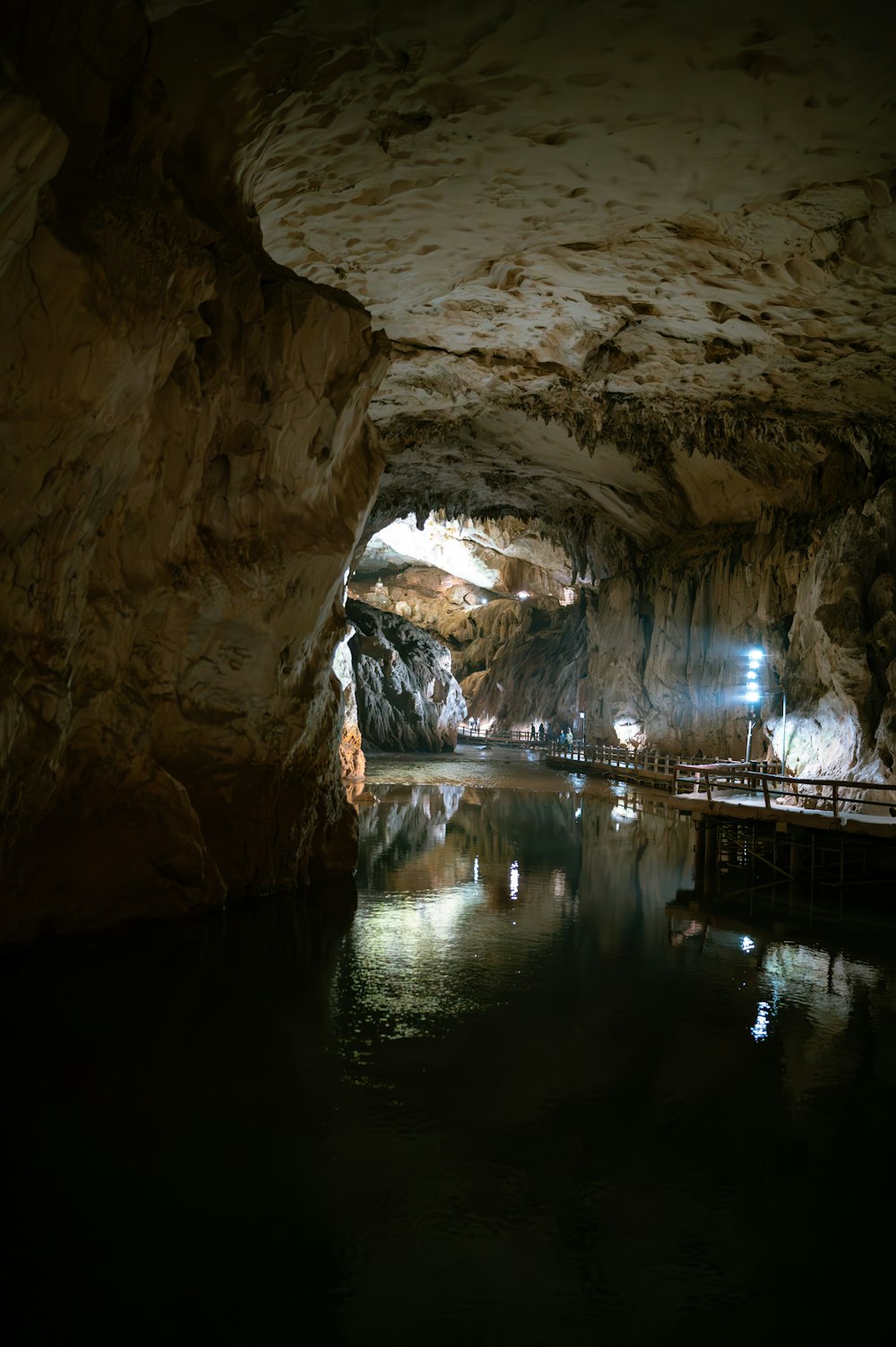 a large cave with a body of water inside of it