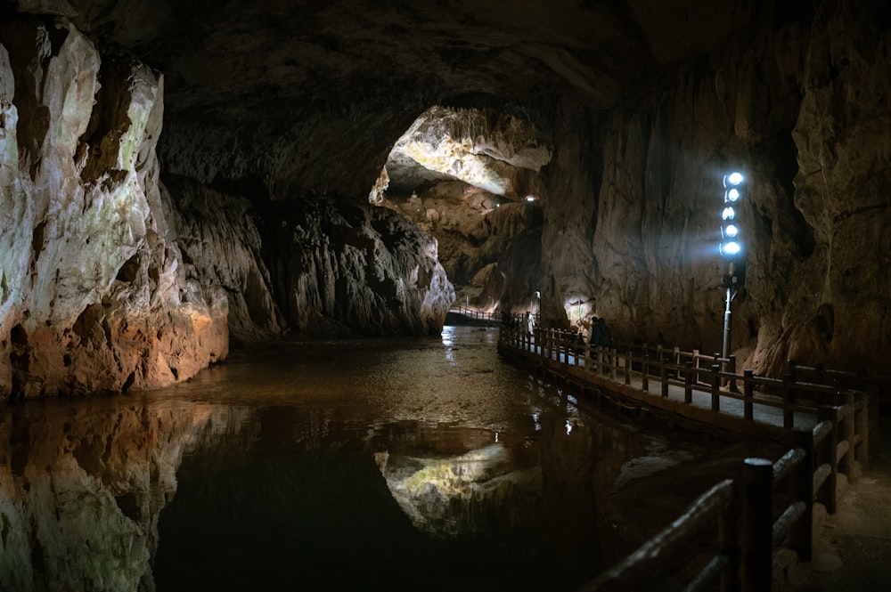 a large cave with a pool of water inside of it