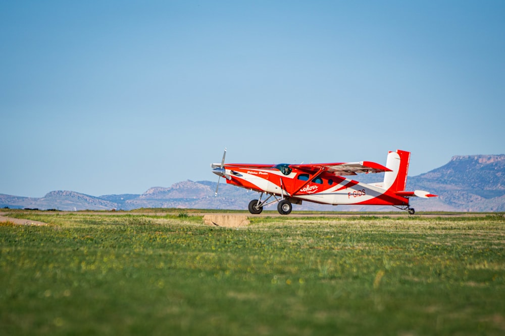 a small red and white plane on a runway