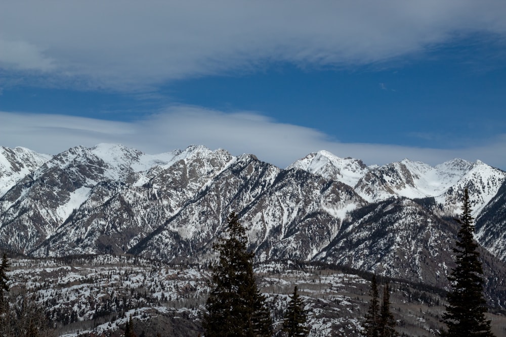 a snow covered mountain range under a blue sky