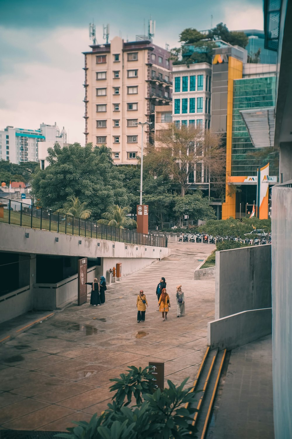 a group of people walking down a street next to tall buildings