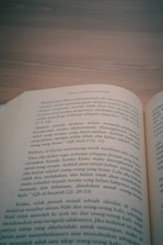 an open book sitting on top of a wooden table