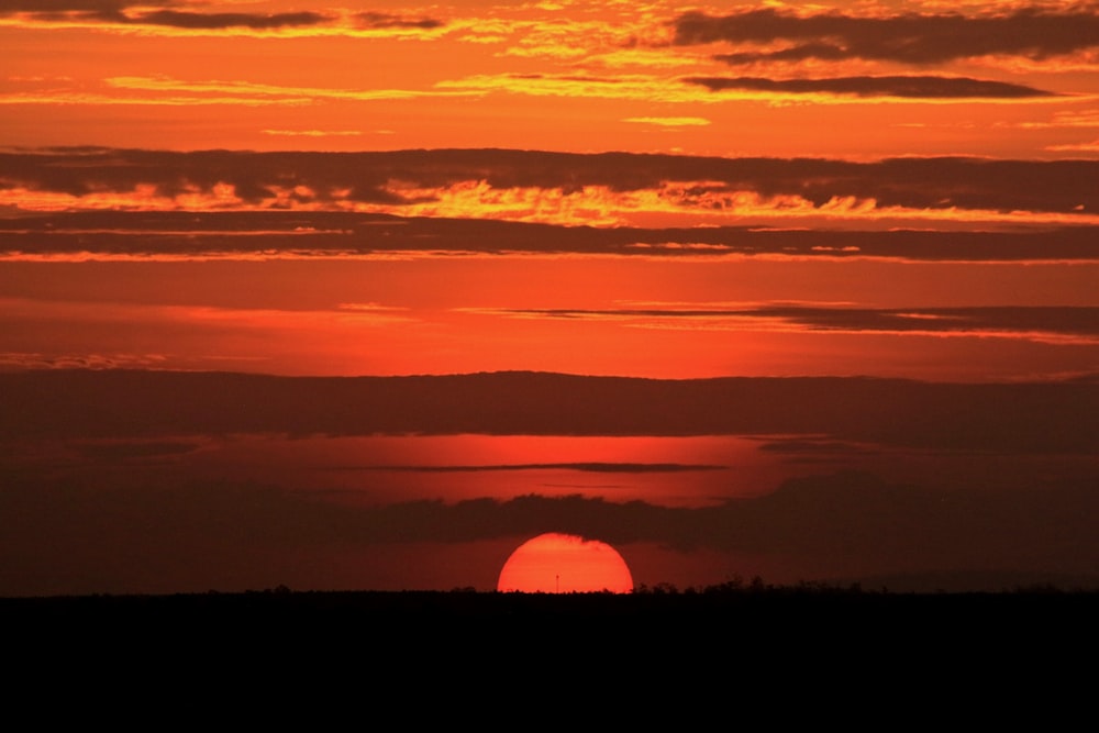 the sun is setting over the horizon of a large body of water