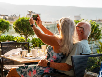 a man and woman sitting at a table taking a picture