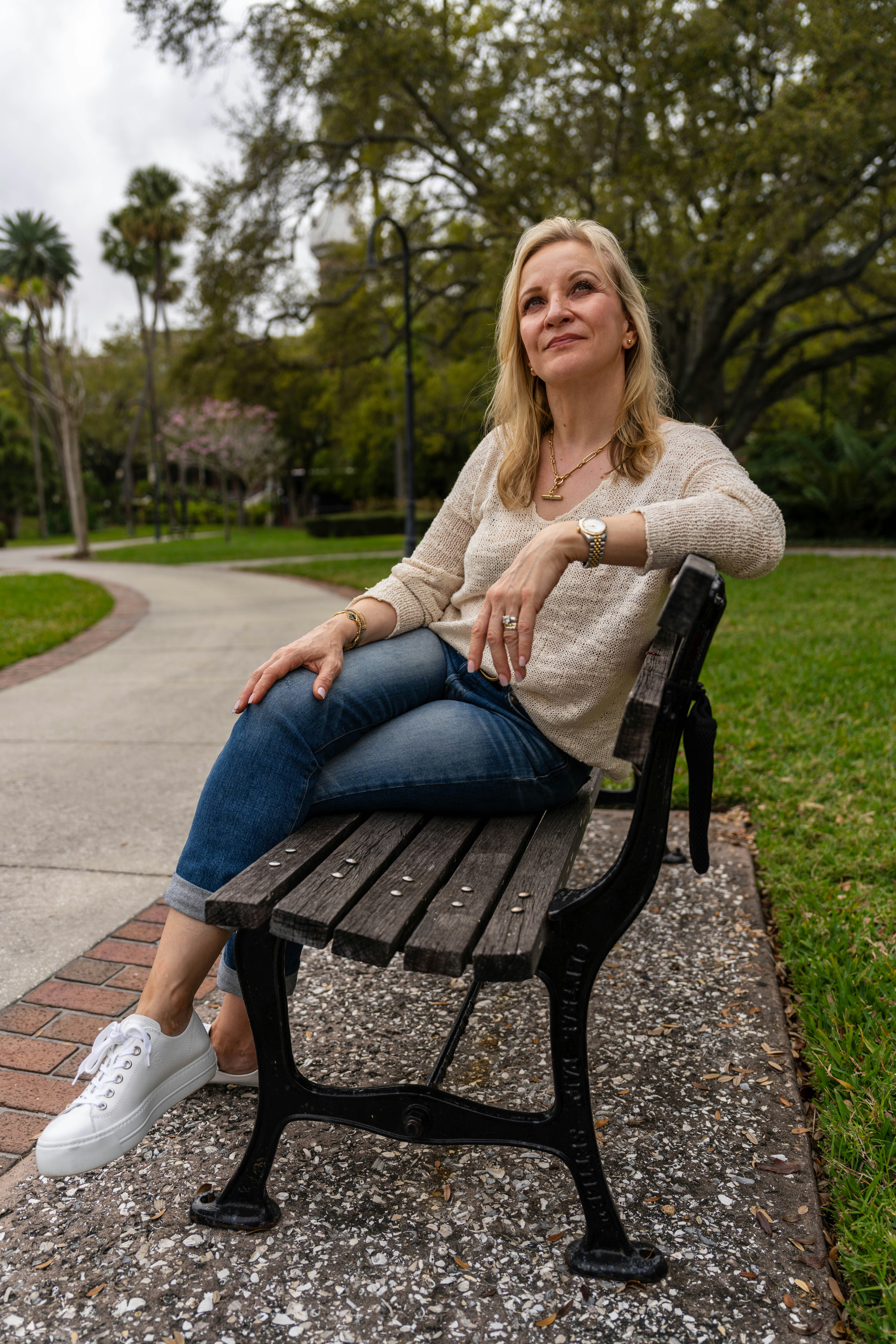 A woman sitting on a bench in a park photo – Free Woman Image on Unsplash