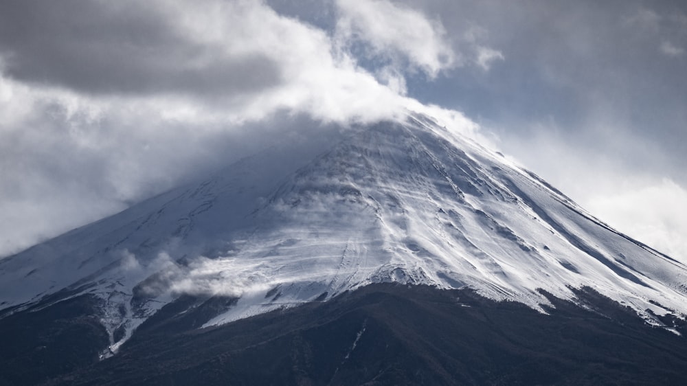 ein großer, schneebedeckter Berg unter einem bewölkten Himmel