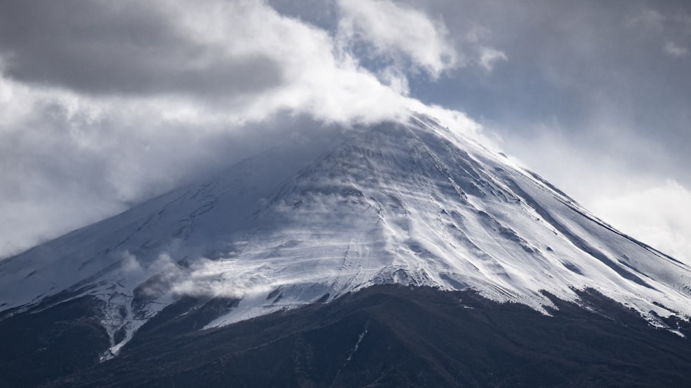 uma grande montanha coberta de neve sob um céu nublado