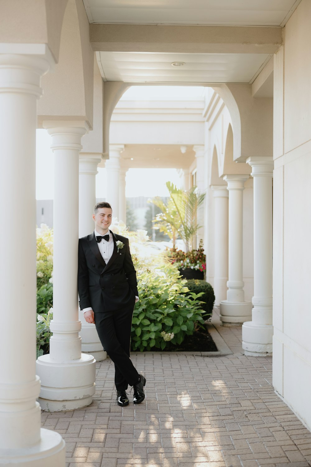 a man in a tuxedo poses for a picture