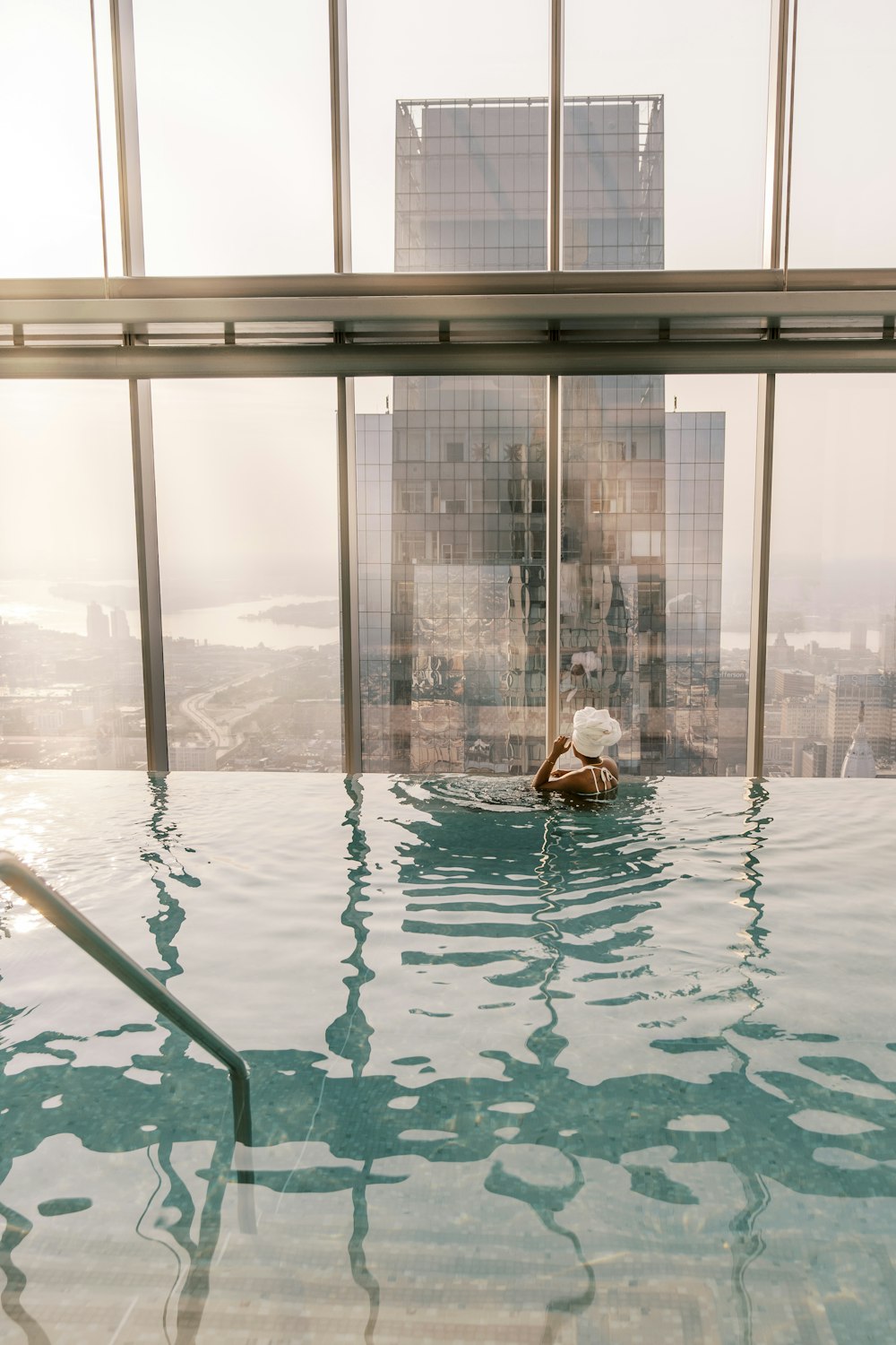 a person in a swimming pool in front of a large window