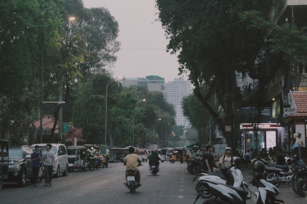 a group of people riding motorcycles down a street