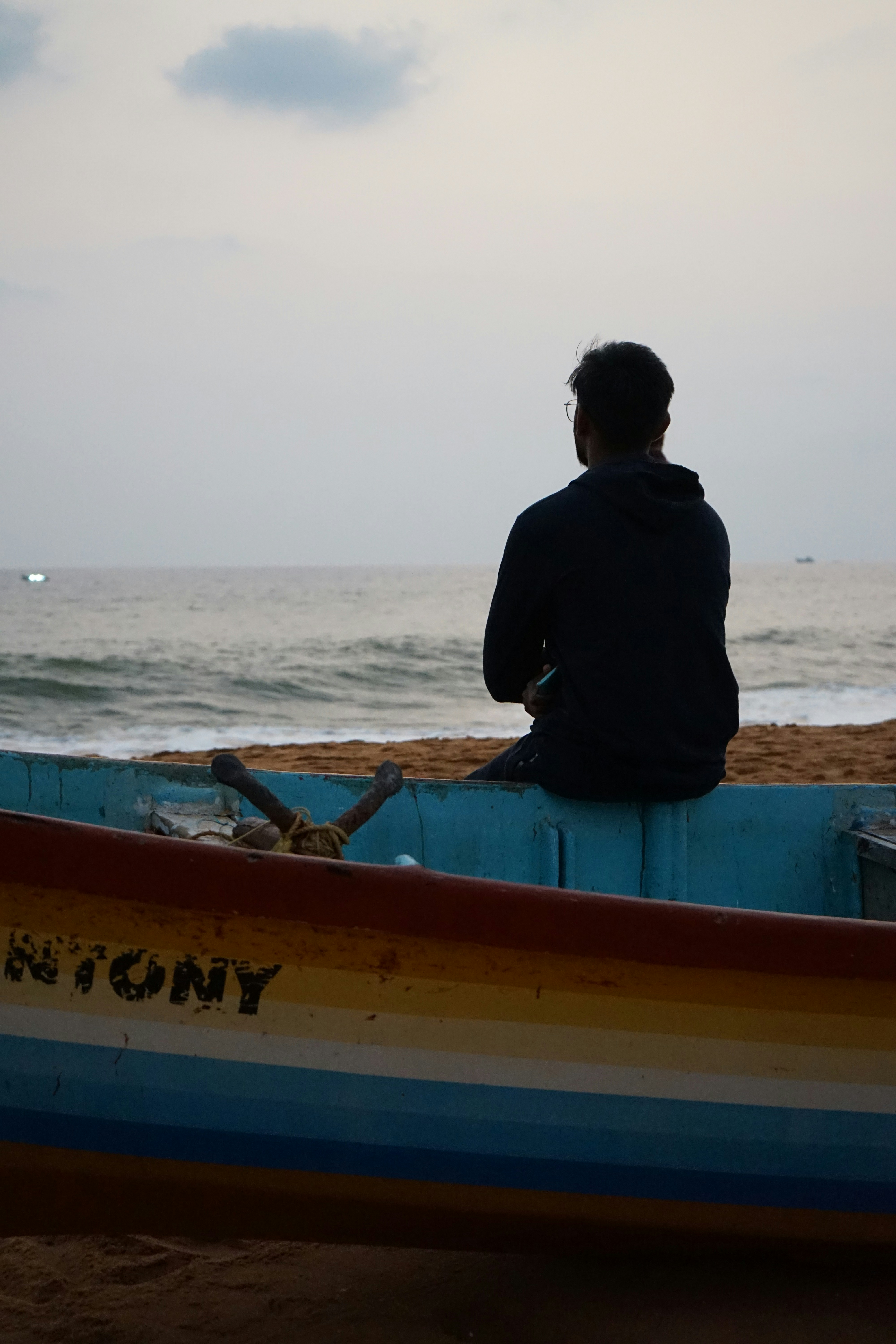 un homme assis dans un bateau sur la plage