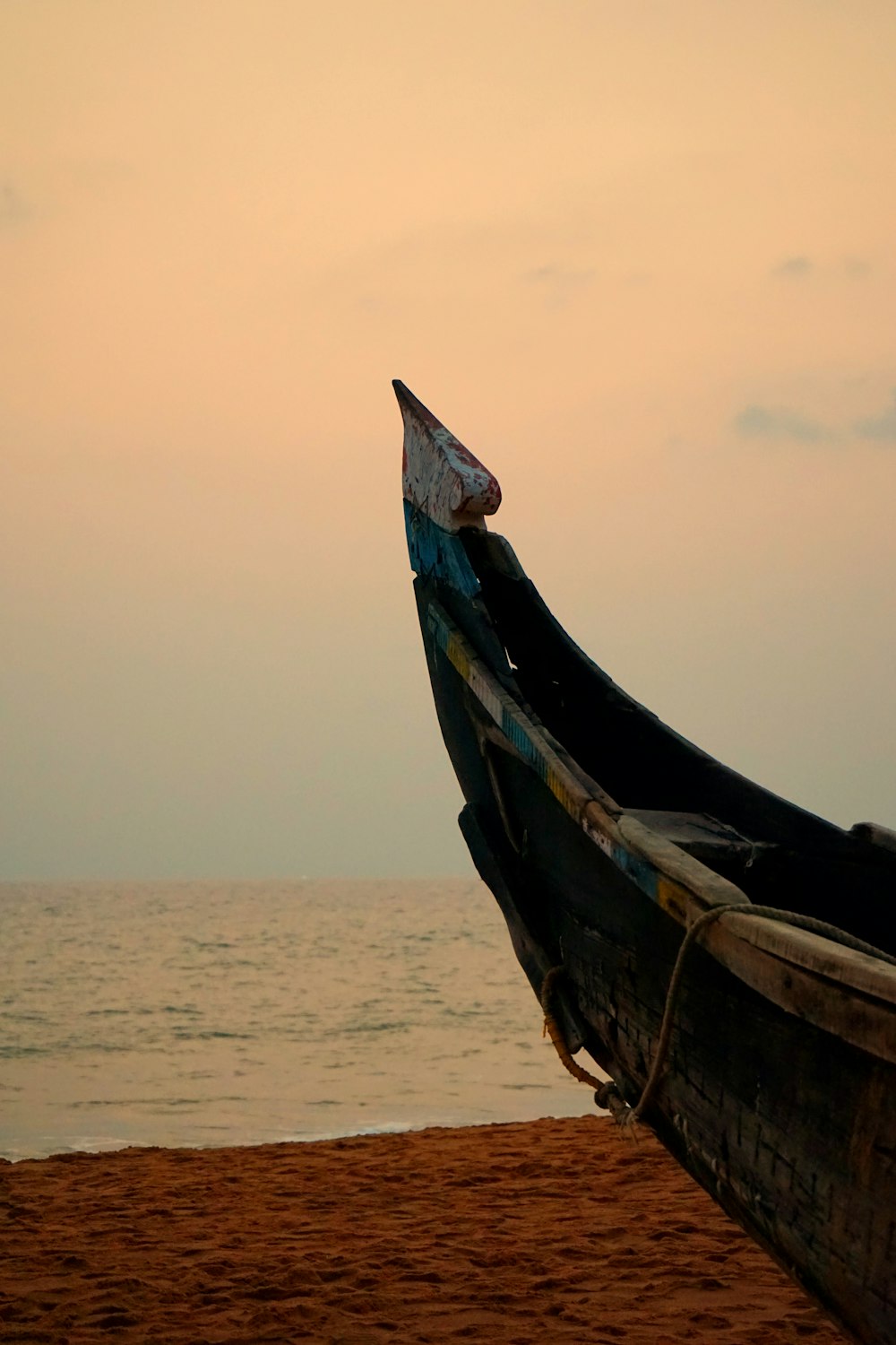 a boat sitting on top of a sandy beach