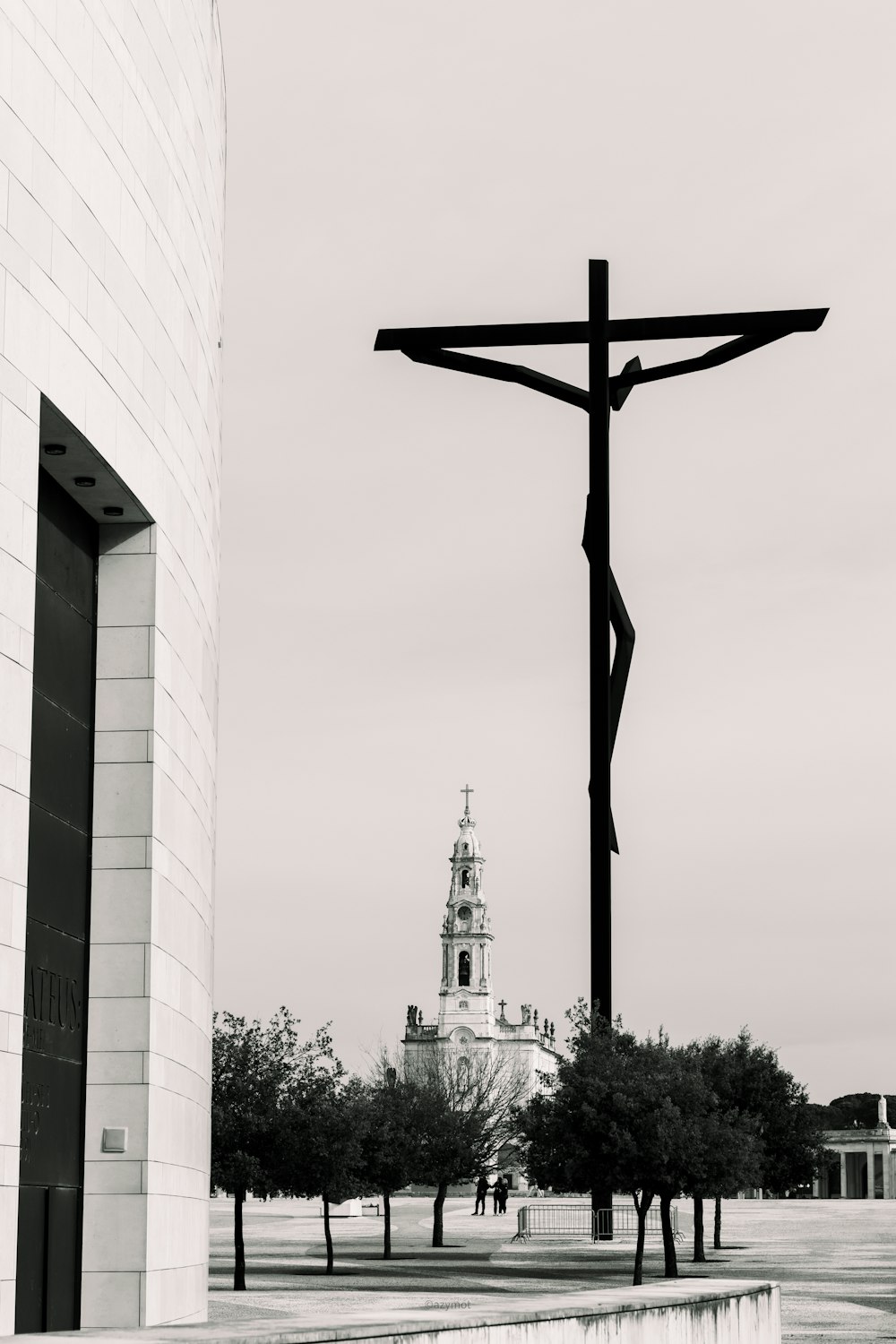 a black and white photo of a cross and a building