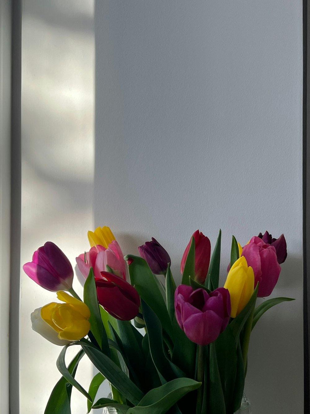 a vase filled with lots of colorful tulips