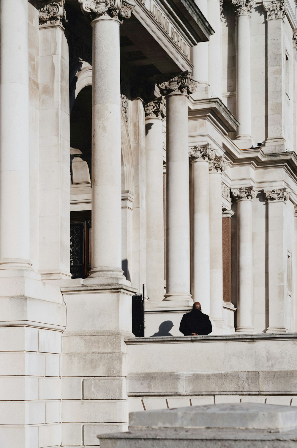 a person sitting on a ledge of a building