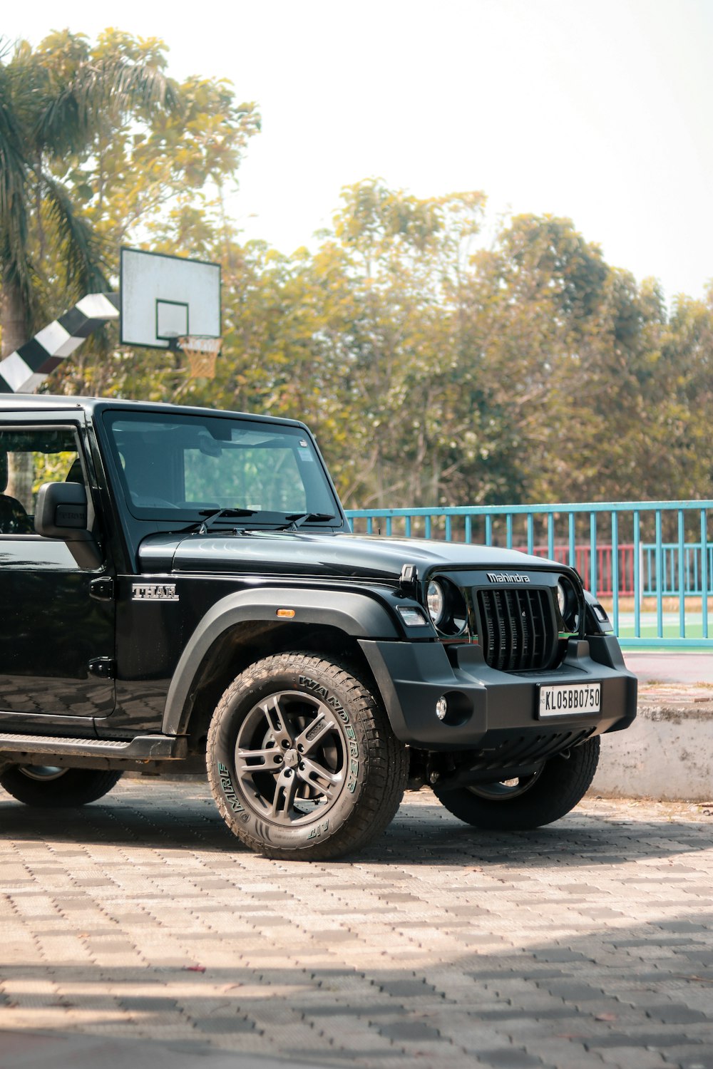 a black jeep parked in front of a basketball hoop