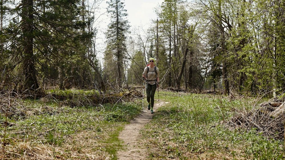 a man walking through a forest on a trail