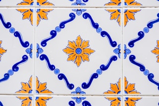 a close up of a tiled wall with blue and orange designs