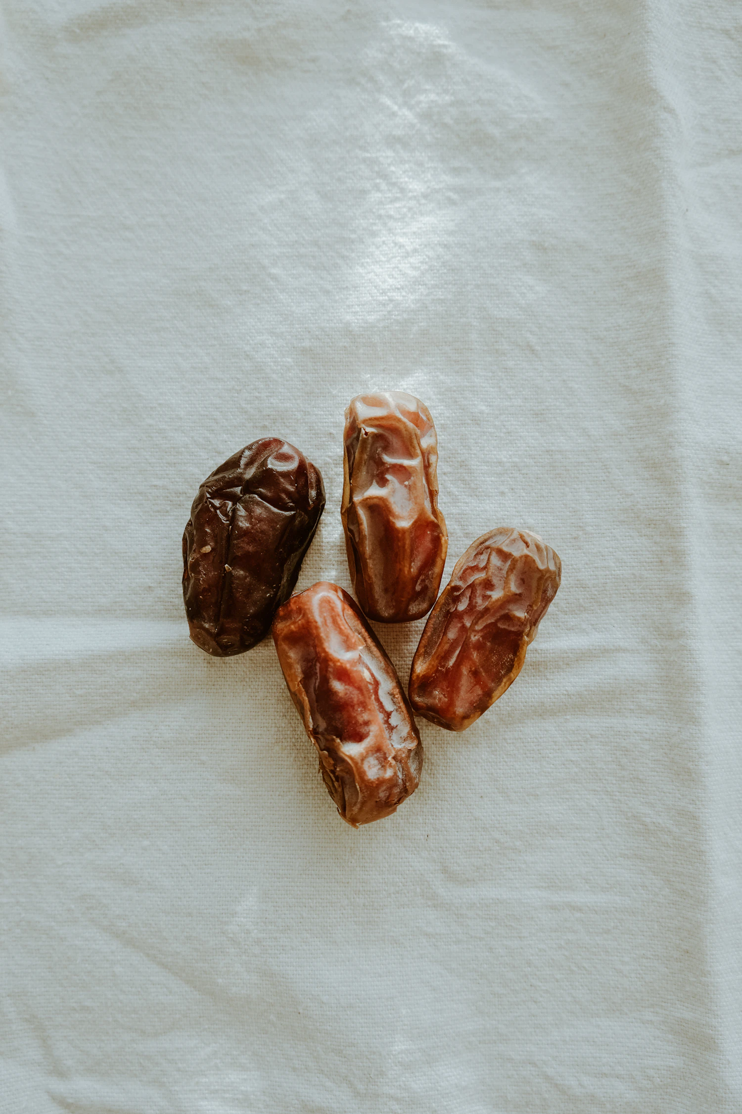 Four Jumbo Medjool dates on white linen