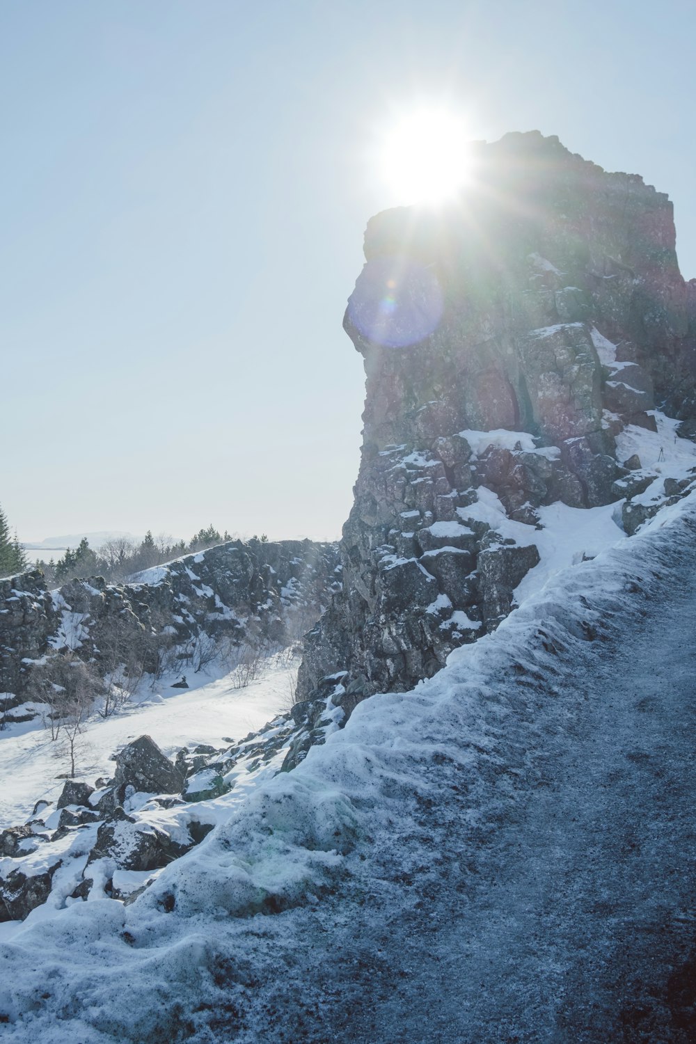 Die Sonne scheint hell auf einen verschneiten Berg