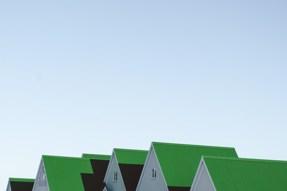 a row of houses with green roofs against a blue sky