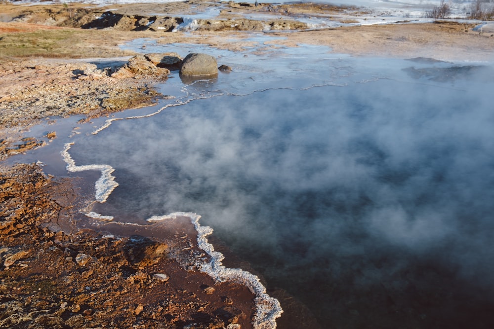 a body of water with steam rising from it