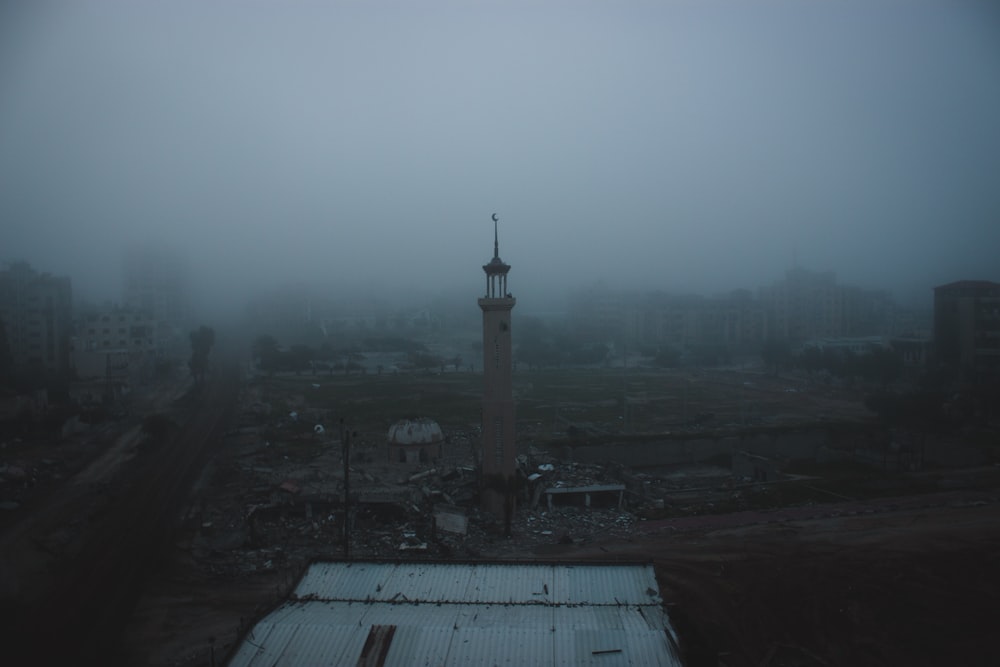 Una ciudad brumosa con una torre en el centro