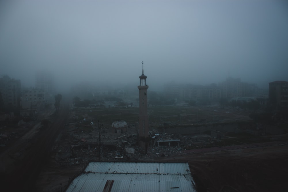 Une ville brumeuse avec une tour au milieu