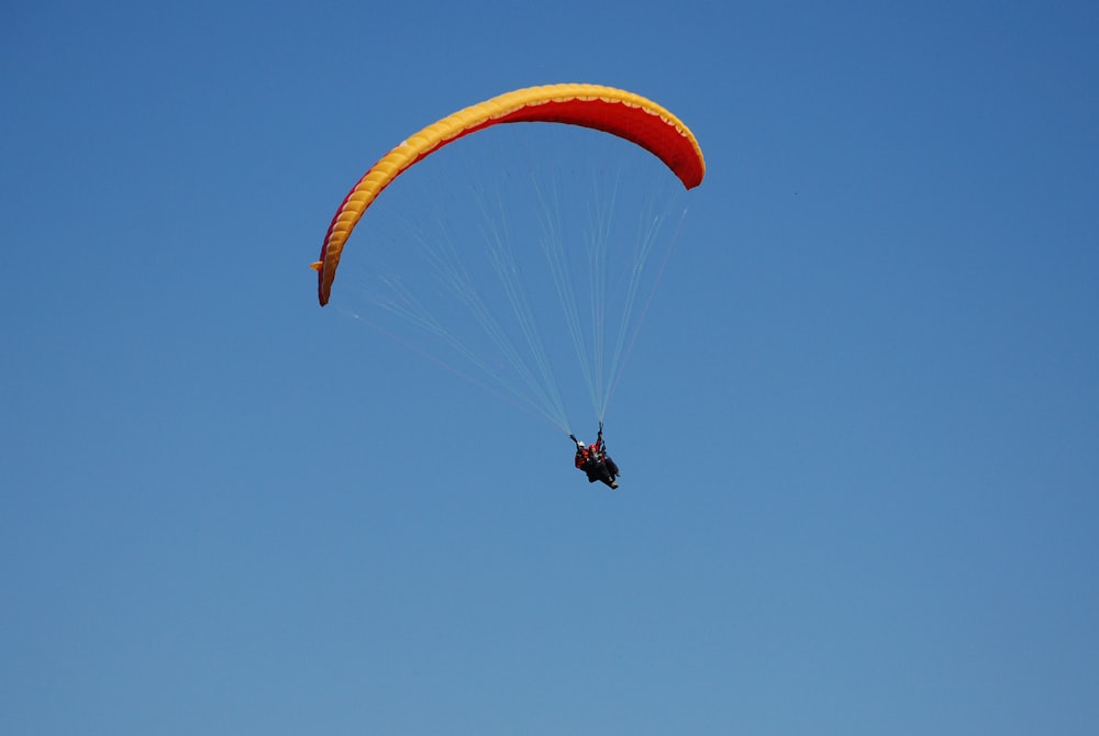 a person is parasailing in the blue sky