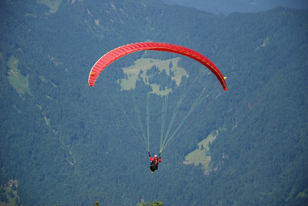 a person is parasailing over a mountain range