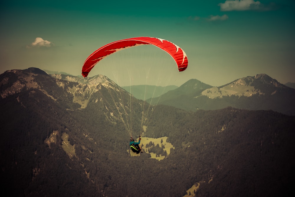 a person is parasailing over a mountain range