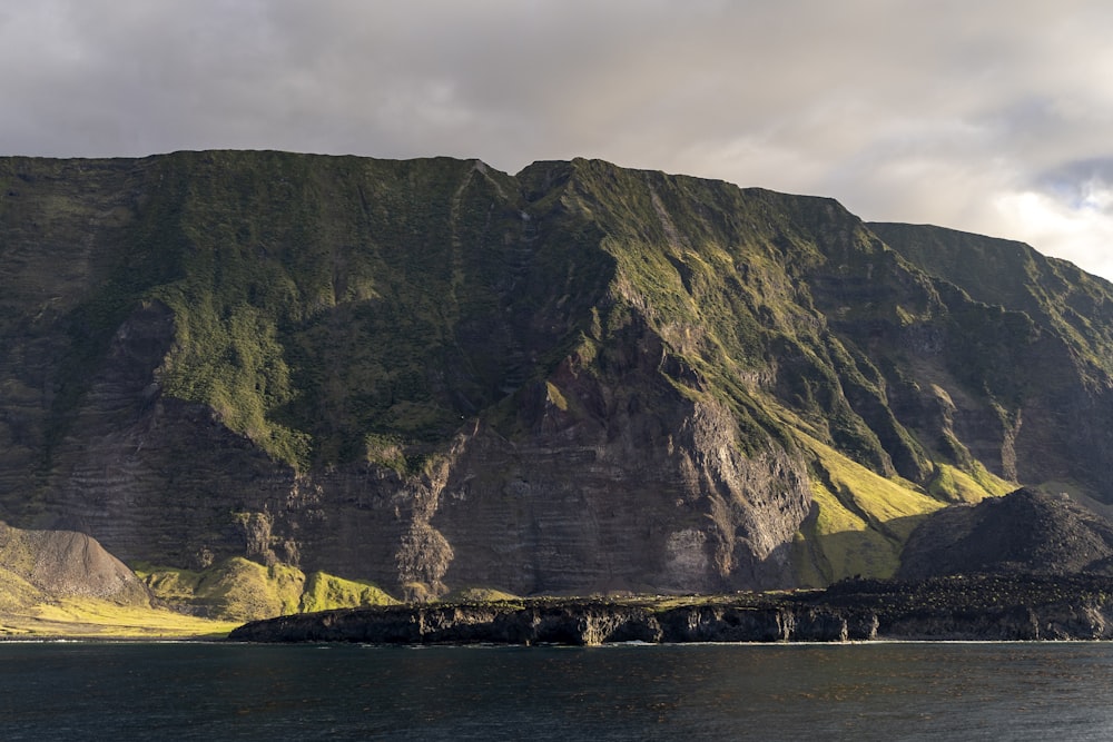 a large mountain with a body of water in front of it