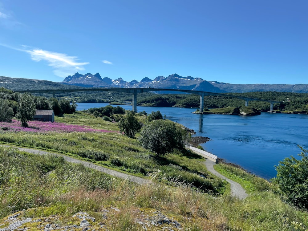 Una veduta di un ponte su un fiume con montagne sullo sfondo