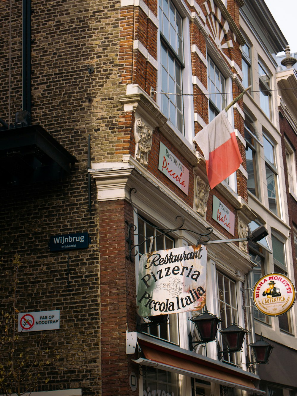 a brick building with a restaurant sign hanging from it's side