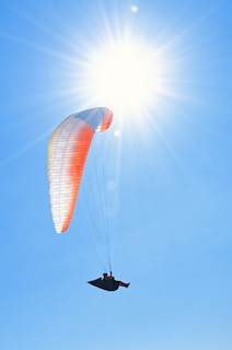 a person parasailing in the sun on a clear day