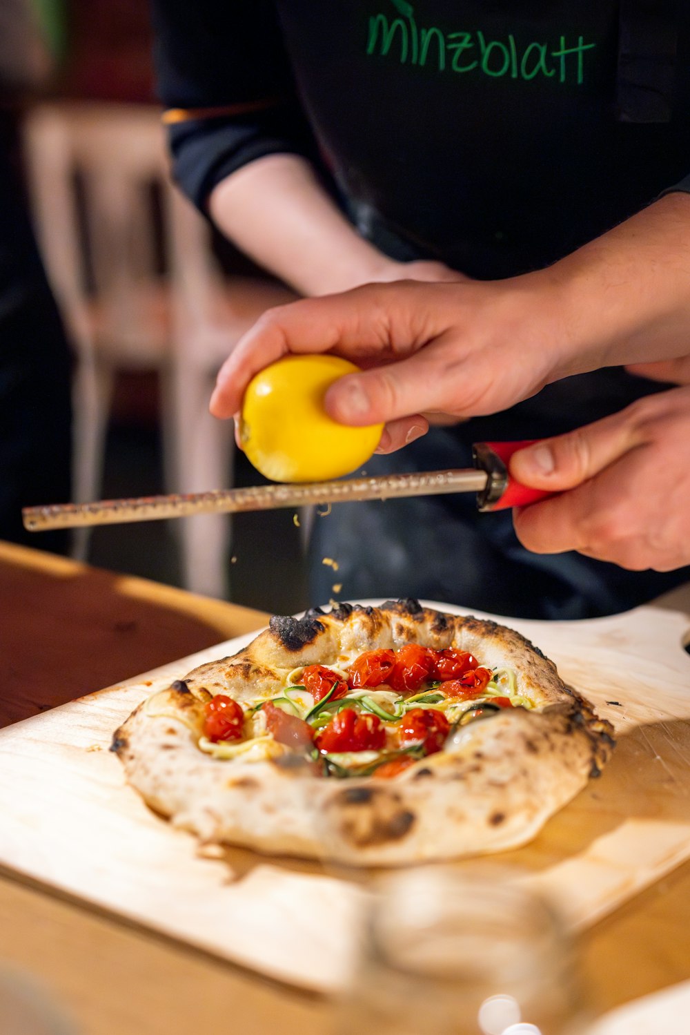 a person cutting a pizza on a cutting board