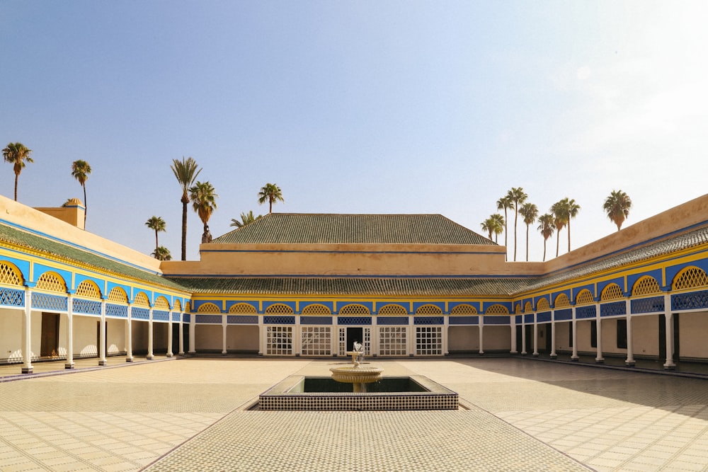 a courtyard with a fountain surrounded by palm trees