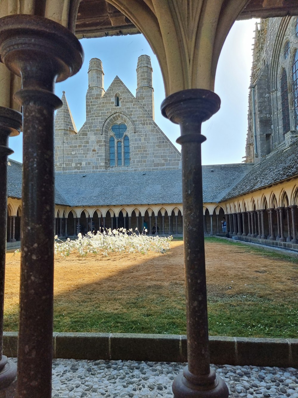 a courtyard with columns and a building in the background