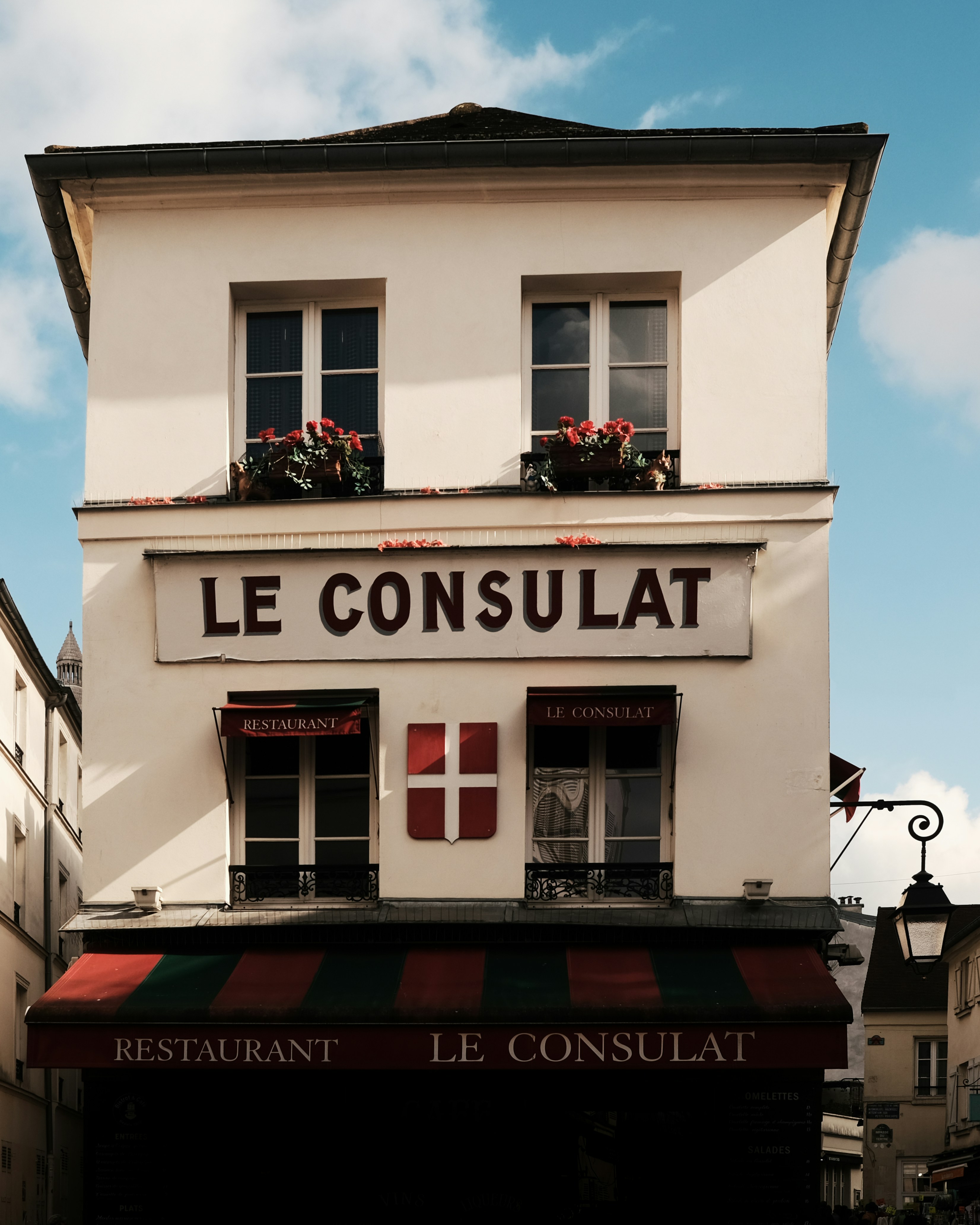 un bâtiment blanc avec un auvent rouge et vert