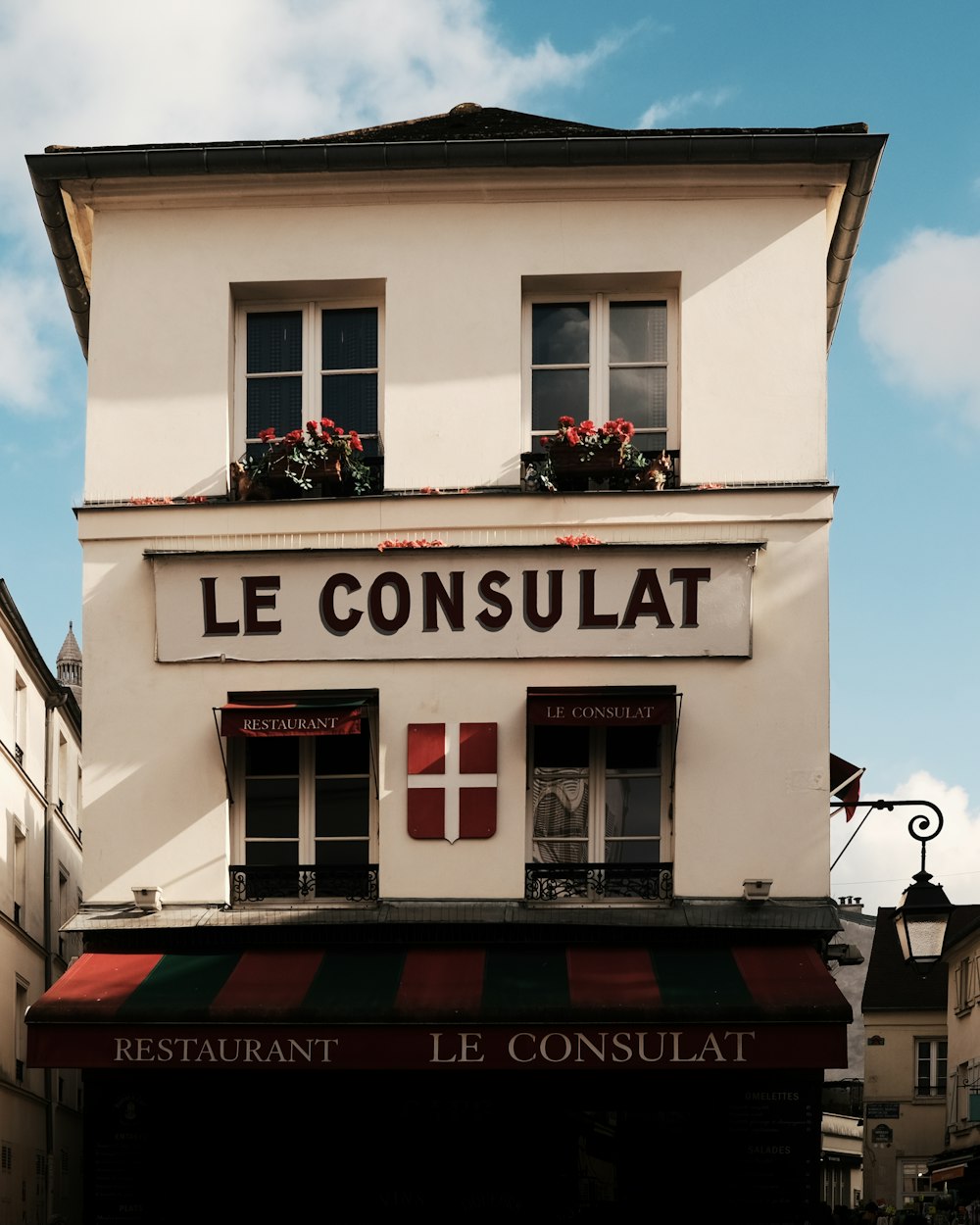 a white building with a red and green awning