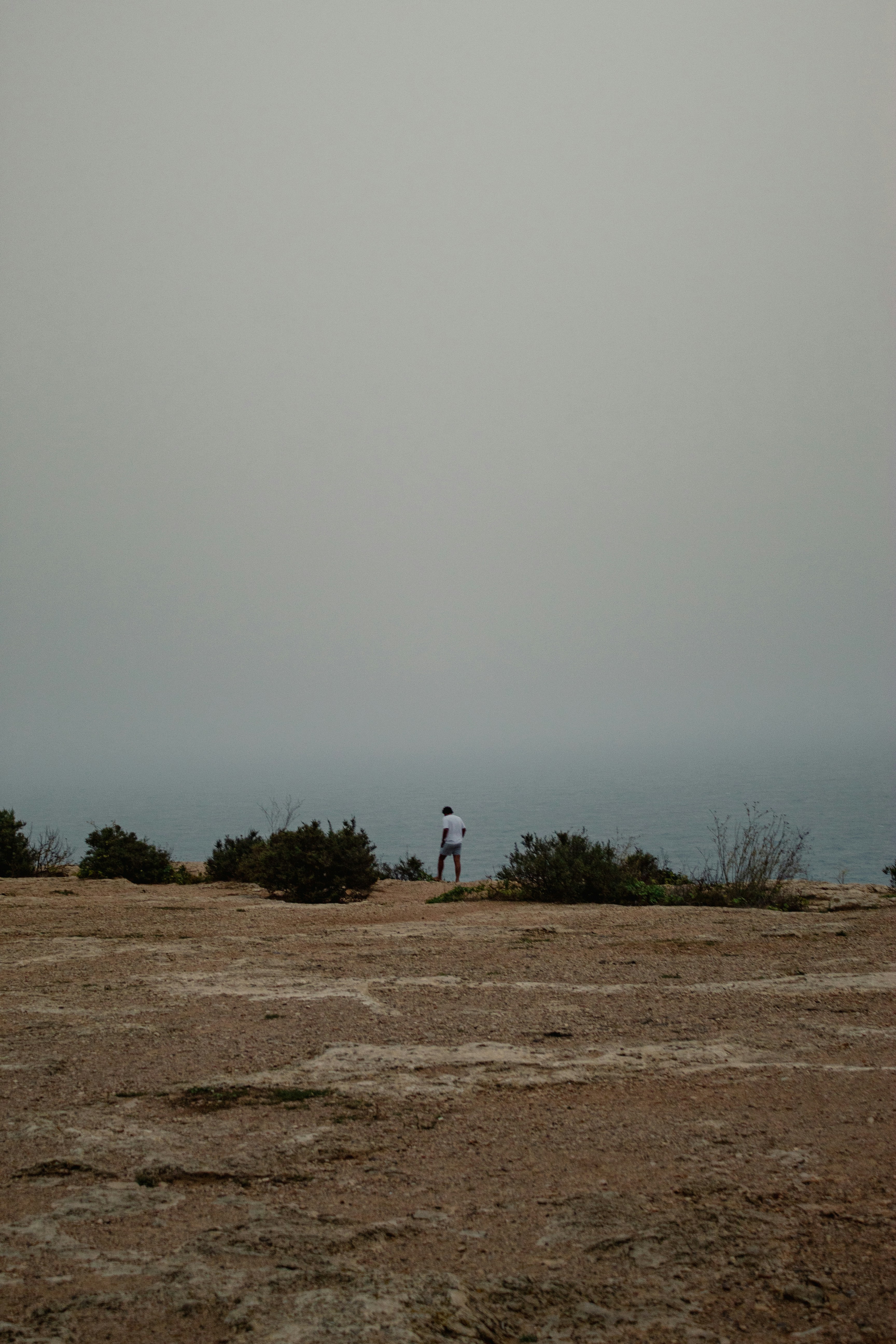 a man standing on top of a dry grass covered field