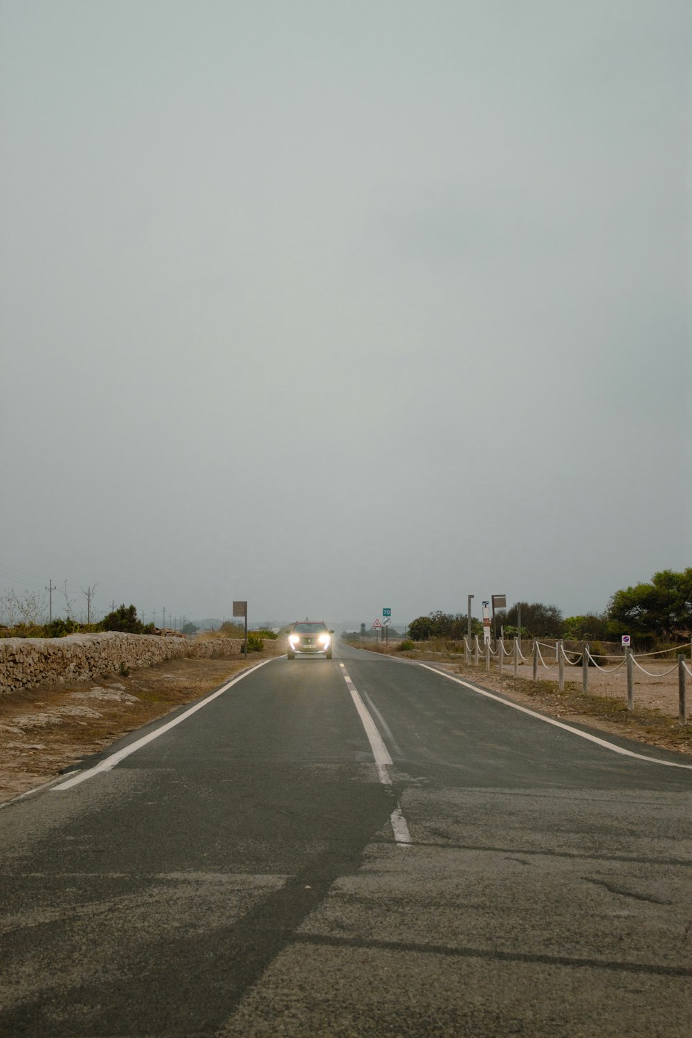two cars are driving down the empty road