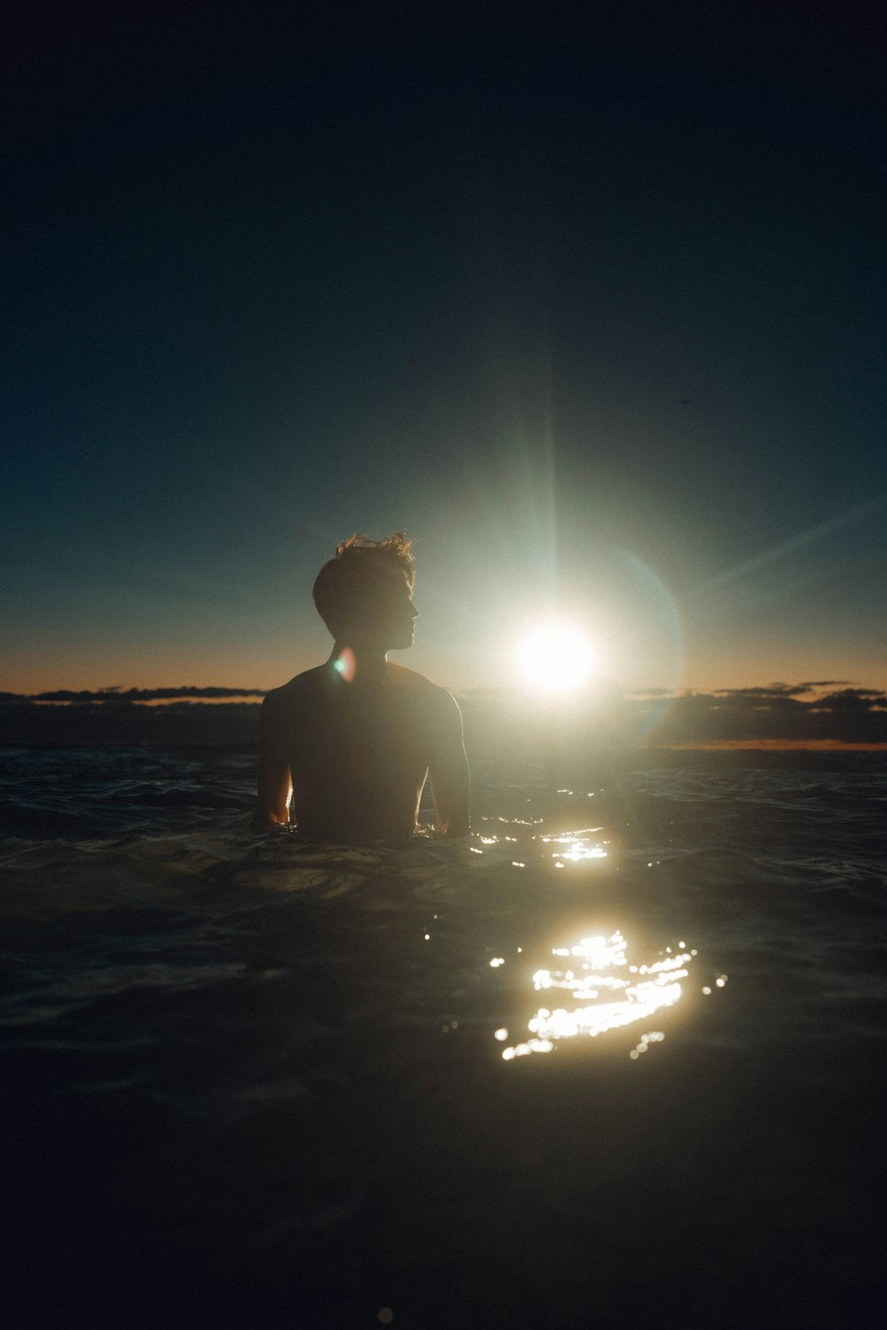 a man standing in the water with a surfboard