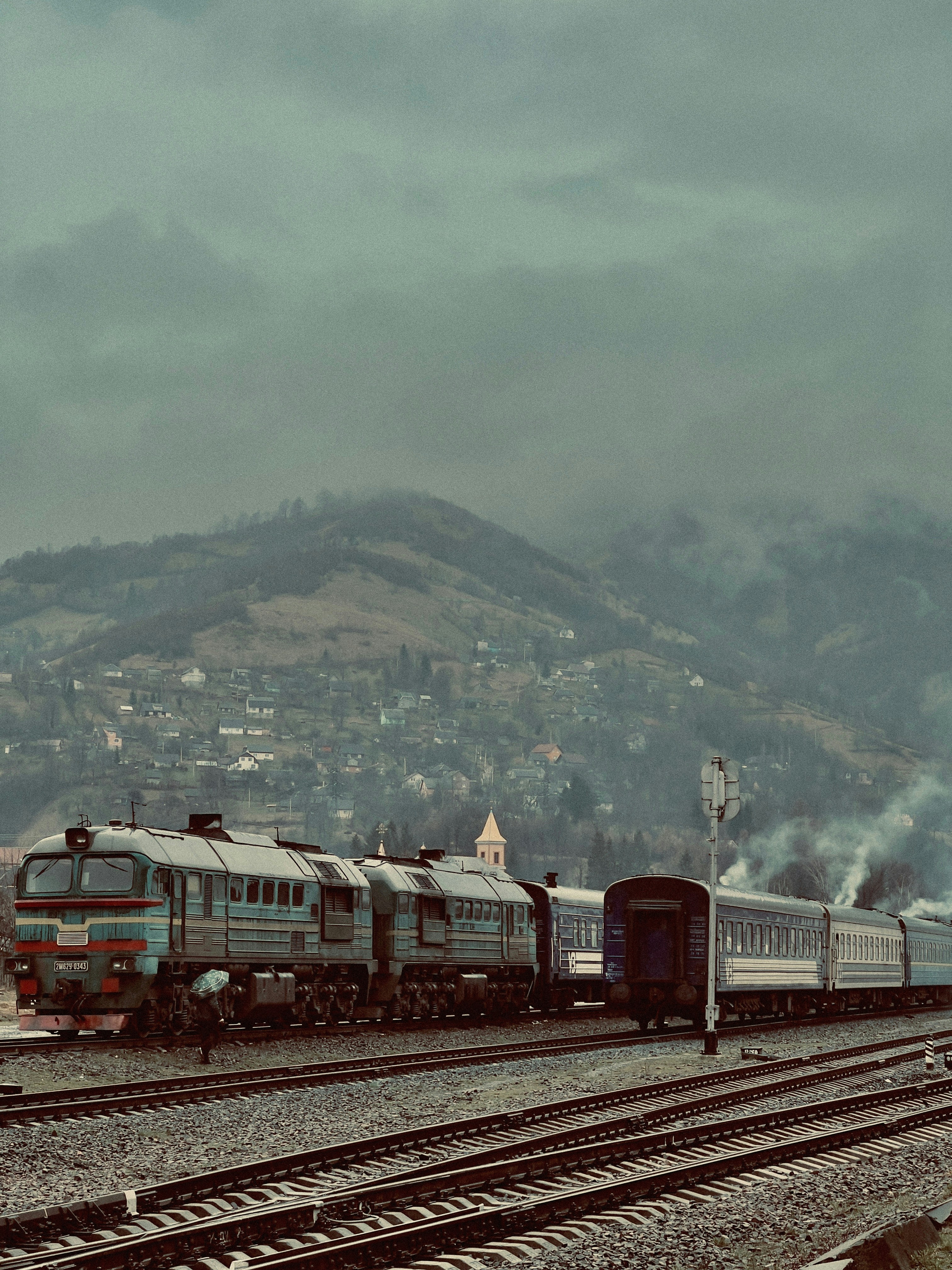 a train traveling down train tracks next to a mountain