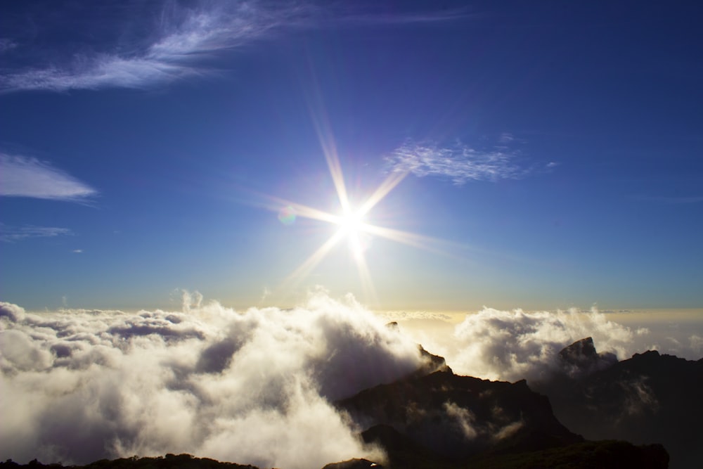 the sun is shining above the clouds in the sky