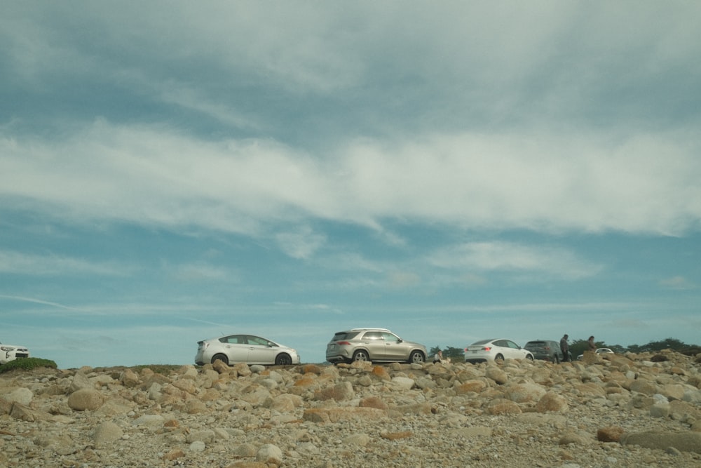 a group of cars parked on top of a rocky hill