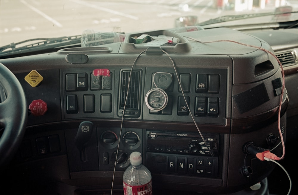 a car dashboard with a radio and a bottle of water