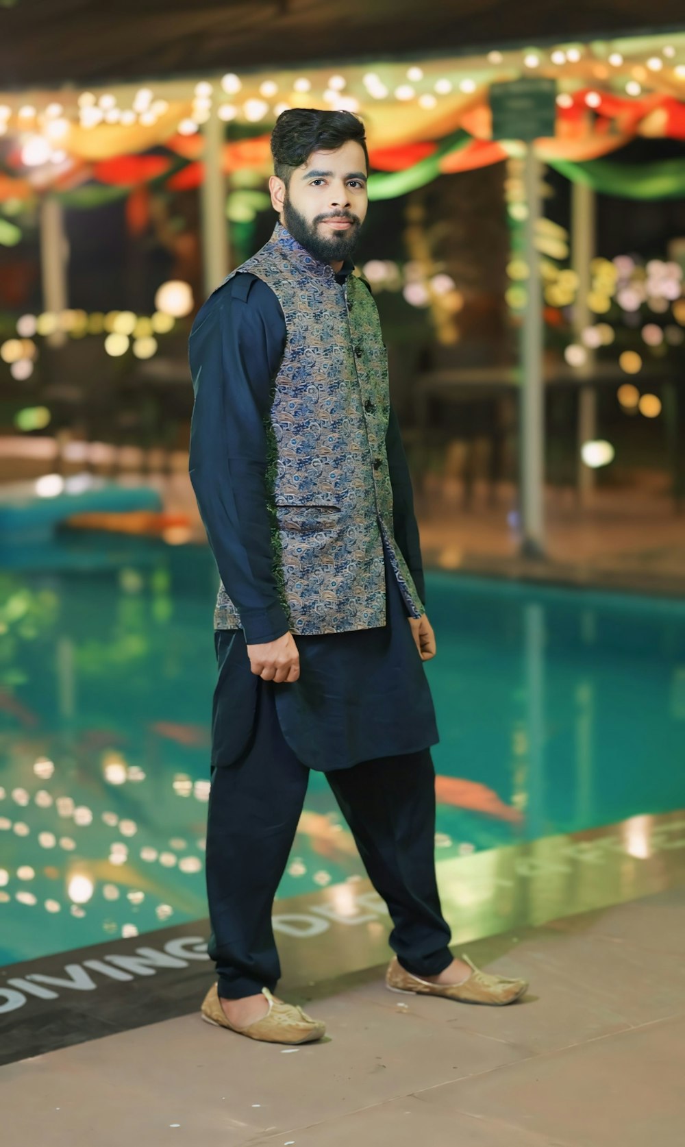 a man standing in front of a swimming pool